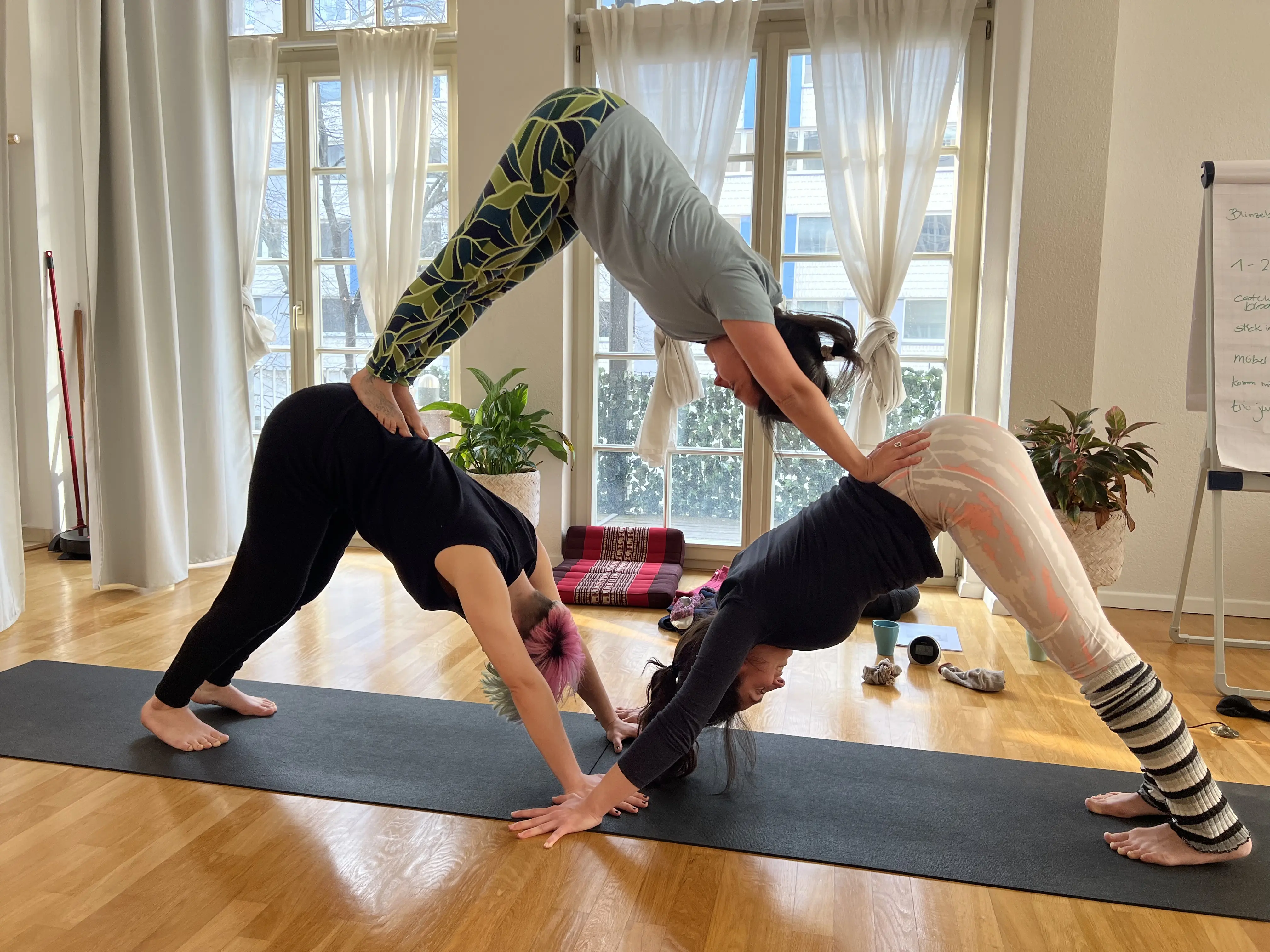 Partner-Yoga-Variante zu zweit im hellen Studio